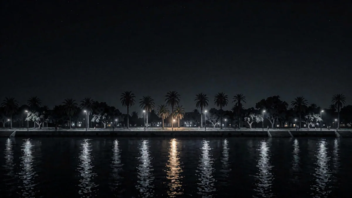 Una costanera sobre un río ancho con luces reflejadas y palmeras