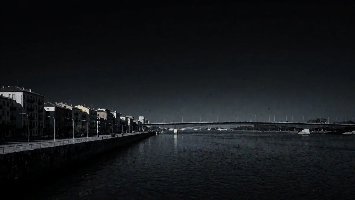 Costanera con un puente de gran luz sobre el río en una noche cálida