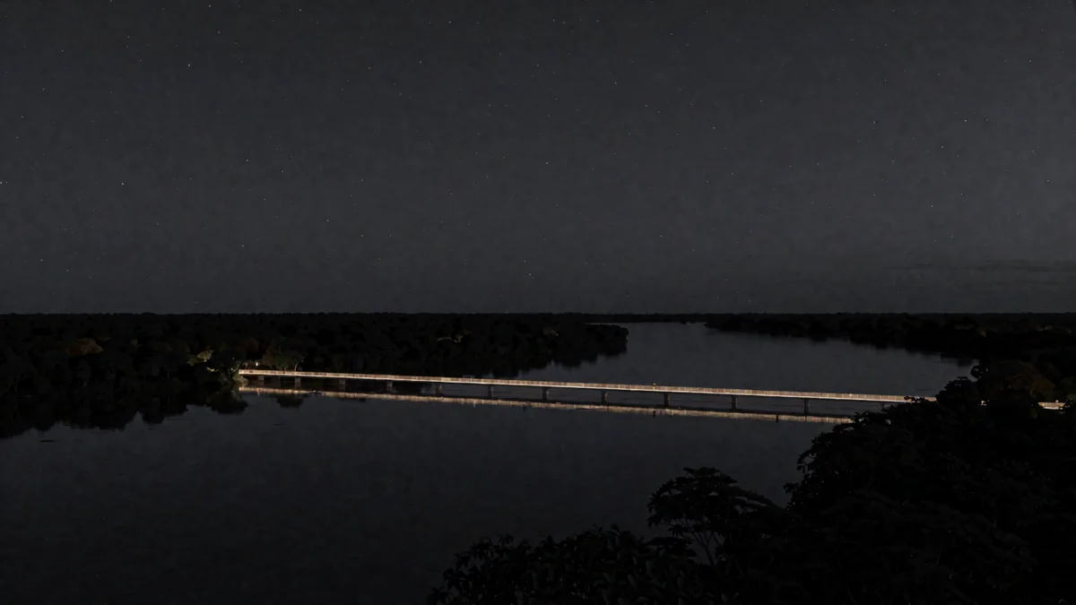Una pasarela sobre un río amazónico con luces cálidas de una ciudad pequeña en hora azul