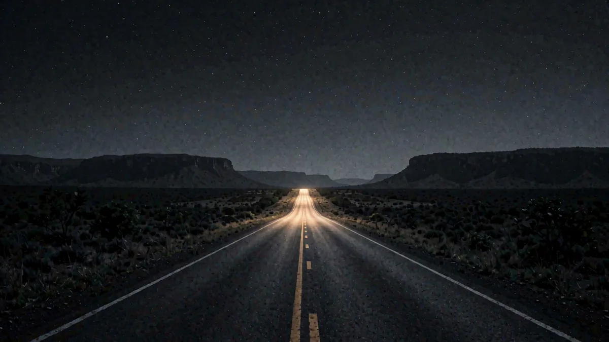 Una carretera recta de sabana con montes tepuy al fondo en hora azul y una luz cálida lejana